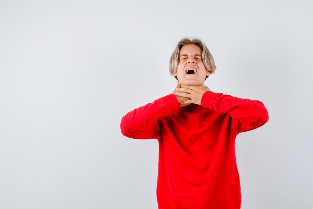 boy singing from his throat in pain